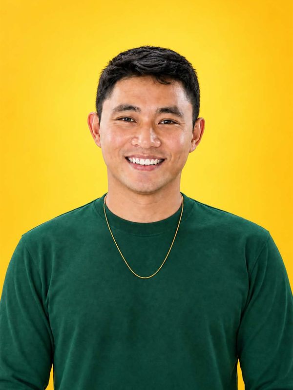 Portrait of Cheenu Malig smiling against a yellow background